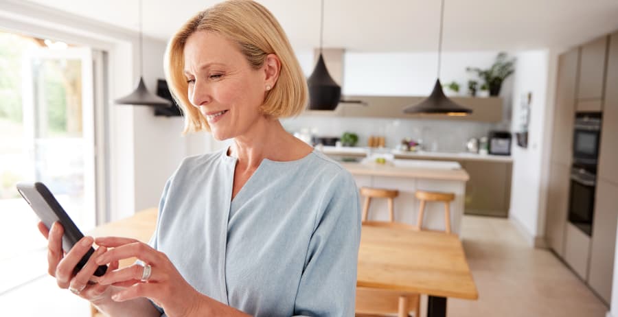 Homeowner using a smartphone in a modern home